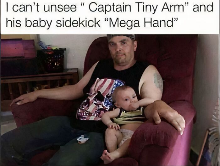 A man sitting with a baby on a red armchair; the mans arm and the babys arm look like a glitch in the matrix.