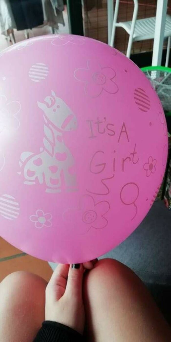 Close-up of a pink balloon with a giraffe and "It's A Girl" text for gender reveal moments.