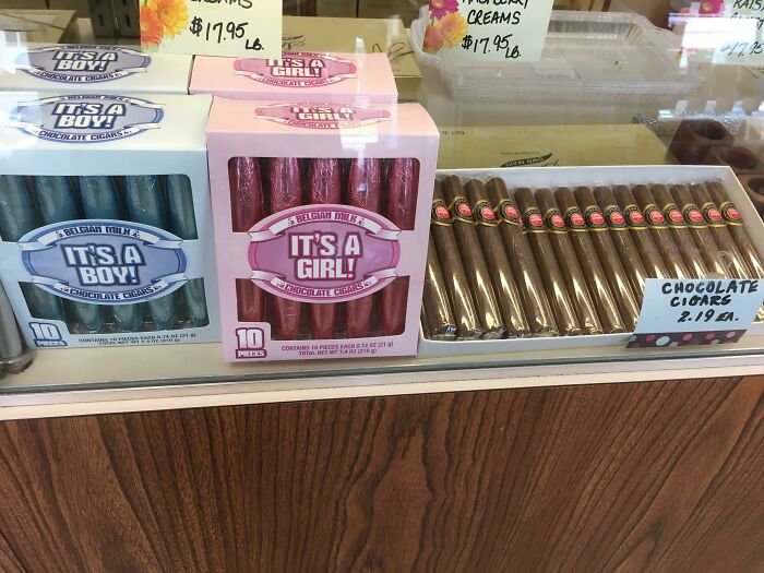 Chocolate cigars in pink It's A Girl! and blue It's A Boy! boxes, displayed for a gender reveal.