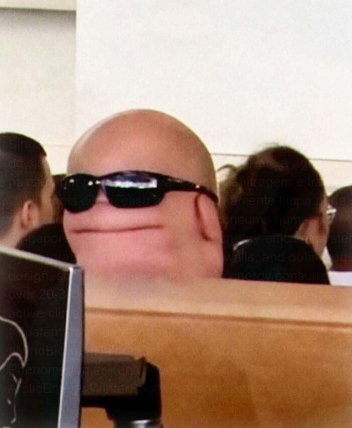 A close-up of a person with a small, round head and sunglasses, an example of unhinged and cringe memes.