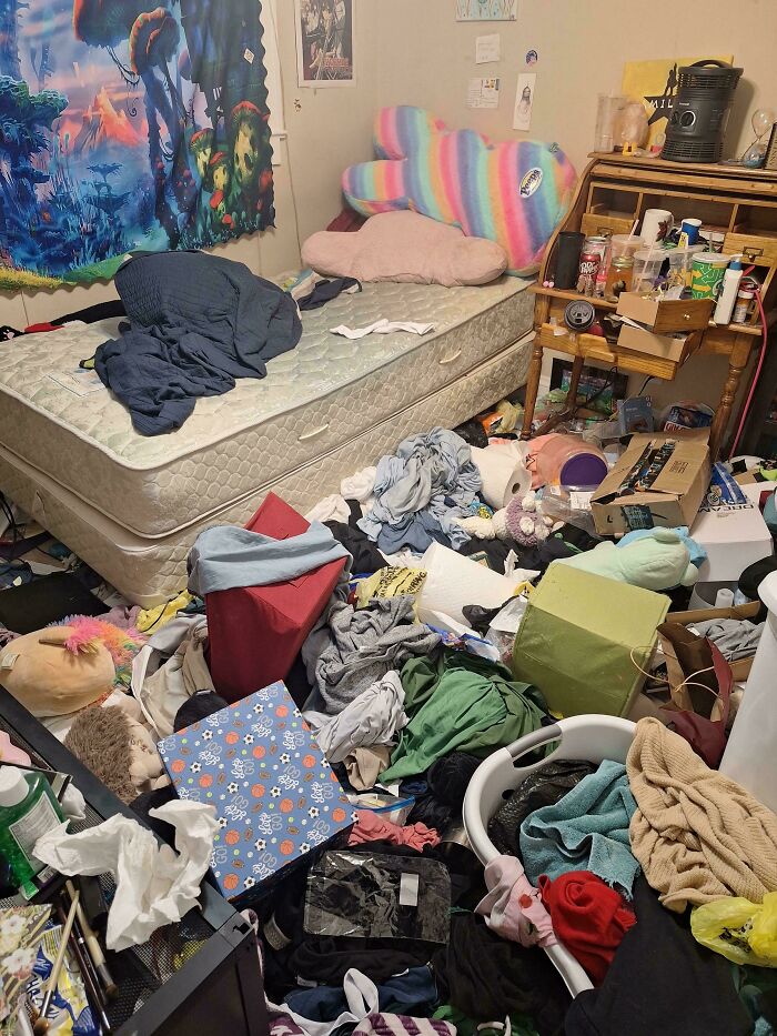 A messy bedroom with clothes and items strewn across the floor and bed, showing a freaked out home.