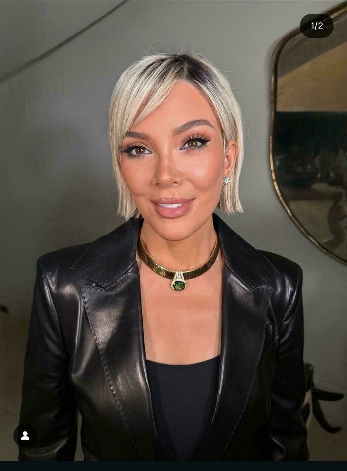 A woman with short blonde hair and a black leather jacket, part of people who didn't try to look natural on social media.