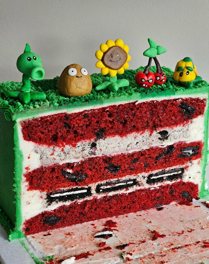 A cross-section of a red velvet cake with Oreo layers and Plants vs. Zombies decorations. Bakers prove treats look amazing and taste delicious.