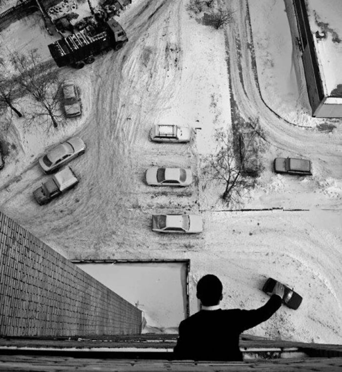 Real photos showing a person looking down at a snow-covered street with cars, making you question if it was edited.