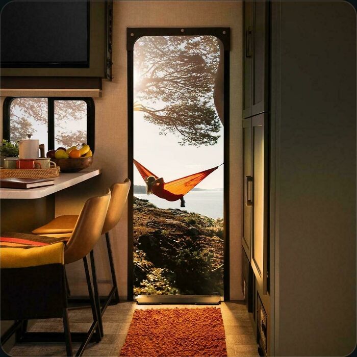 An interior view of an RV showing a person relaxing in a hammock outside through the door, a real photo that questions editing.