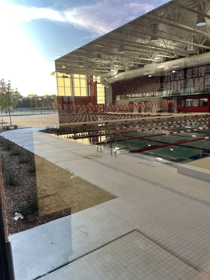 Real photos of an indoor swimming pool reflecting outdoor scenery, making the brain question if they were edited.