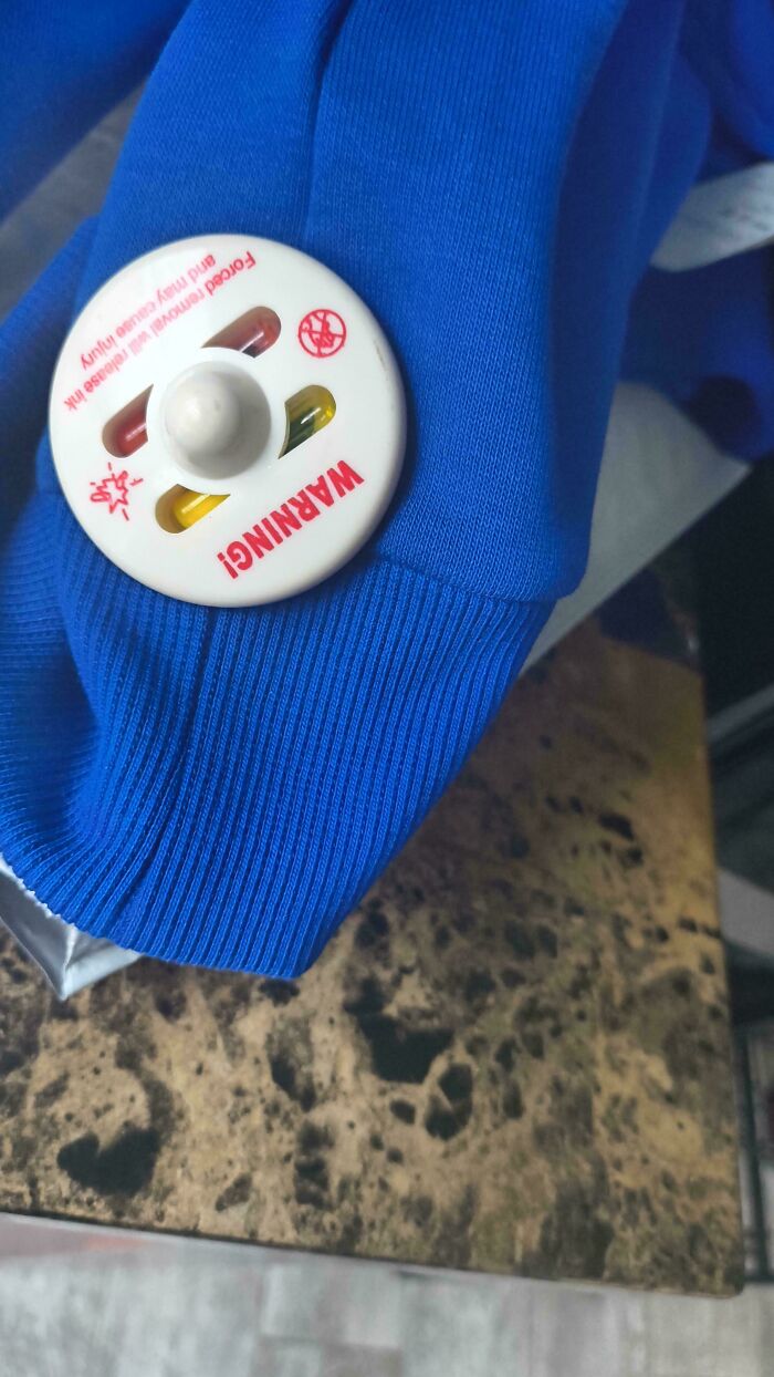 A clothing item with an anti-theft tag still attached, illustrating forgetting something extremely important.