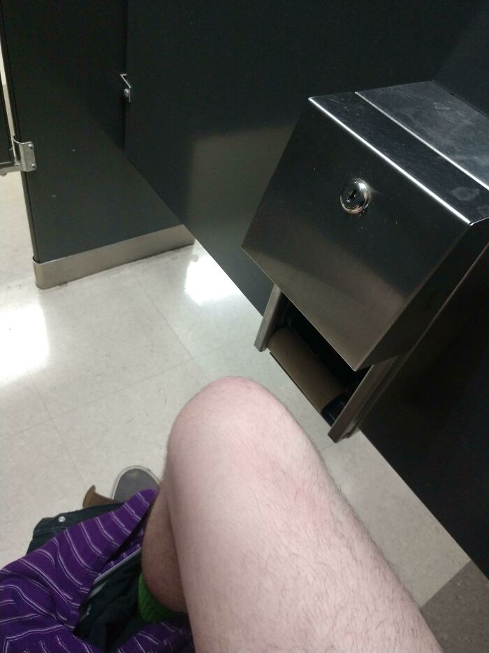 A person on a toilet, realizing they forgot toilet paper, ruining their day.