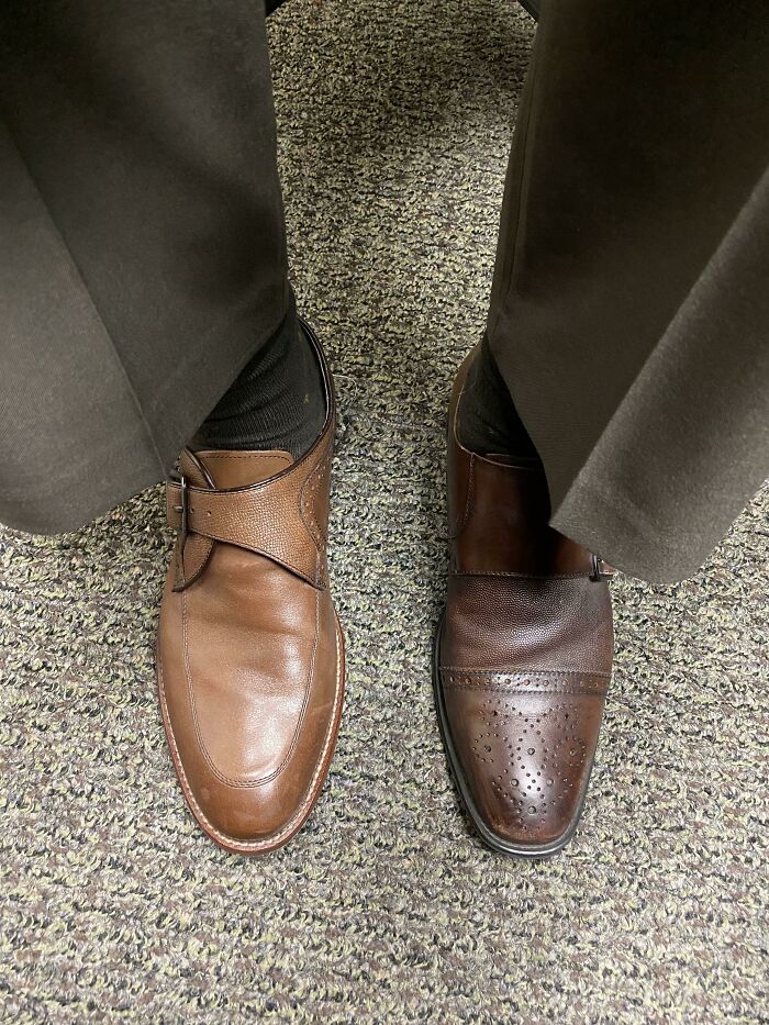 Someone wearing two different brown dress shoes, highlighting the result of forgetting something extremely important.