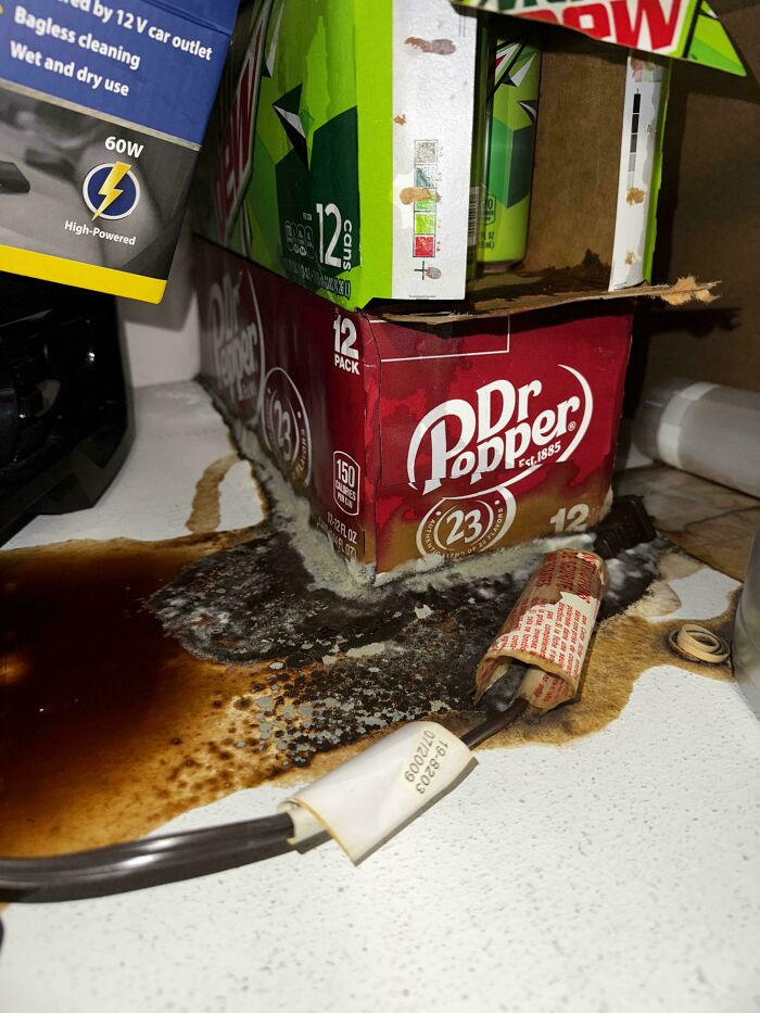 A spilled soda and damaged packaging create a sticky mess, an important ruin of the day due to forgetting something.