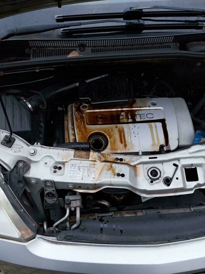 A car engine covered in spilled oil, ruining the entire day by forgetting something important.