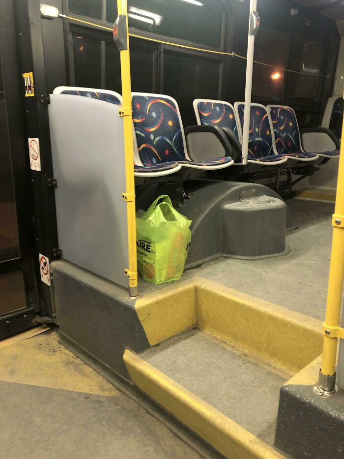 A forgotten green shopping bag left on a bus, ruining someone's day by forgetting something important.