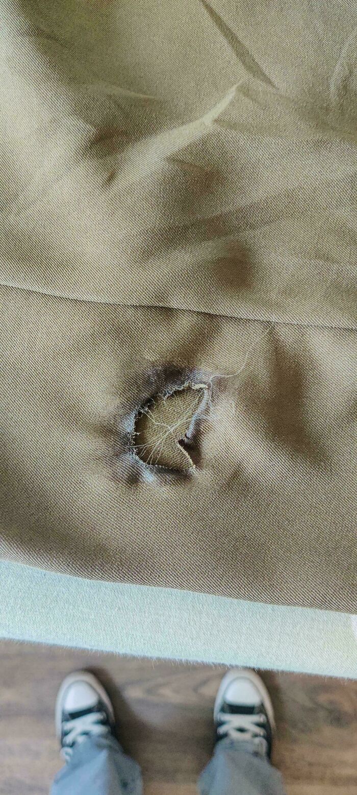 A person looking at a ripped hole in their pants, ruining the entire day.