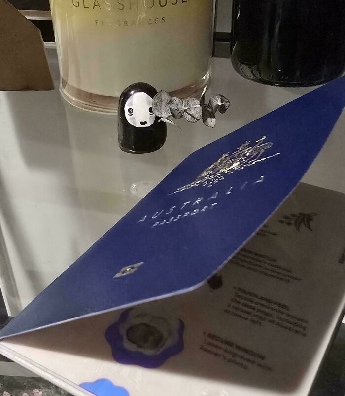A close-up of an Aussie passport with a small figurine and candle in the background. Interesting posts for an Aussie.