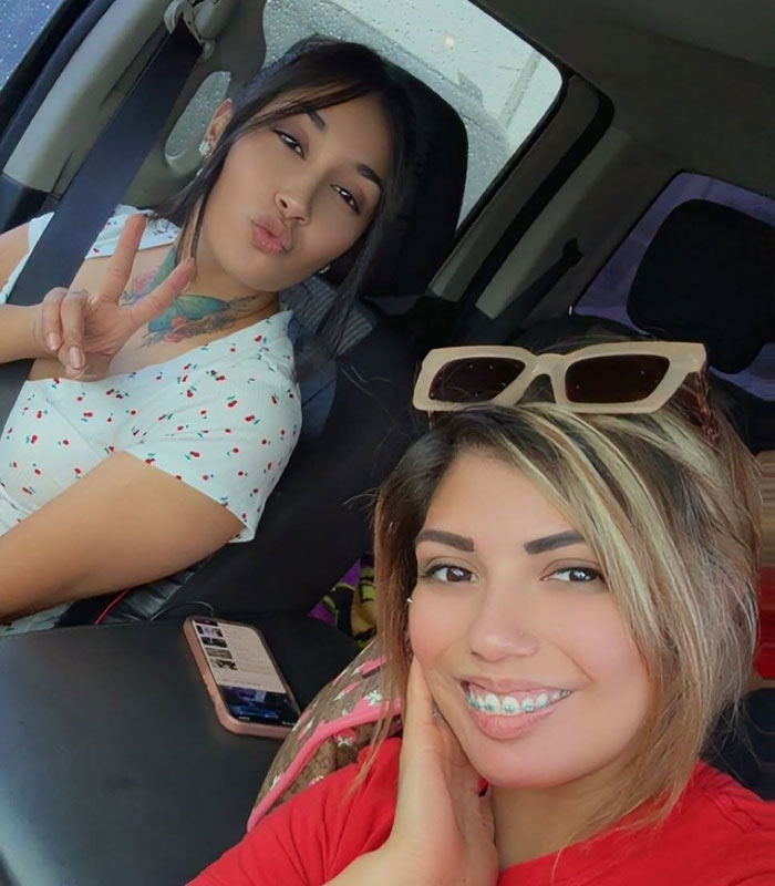Two smiling sisters in a car, the main keyword for this image is brutal attack.