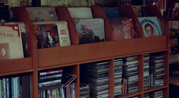 A shelf filled with vinyl records and CDs, offering a wide range of music taste choices.