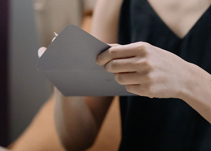 A woman is opening a gray envelope. Many people swear they witnessed reality break for a second.