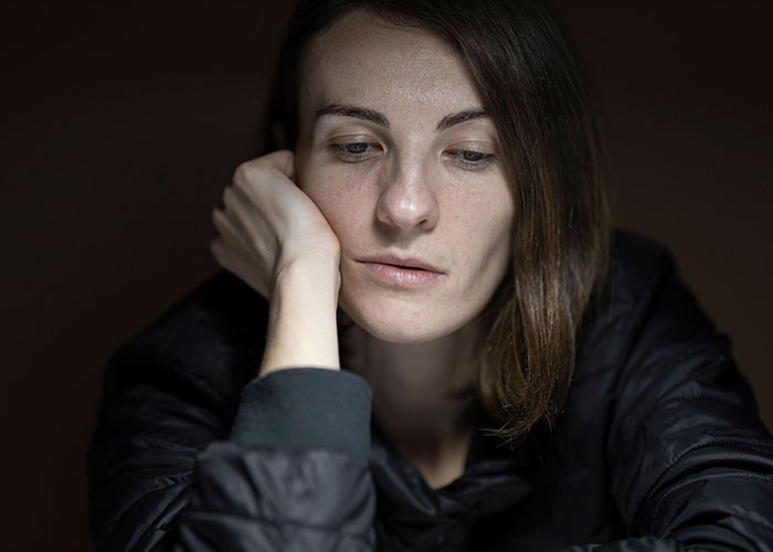 A woman rests her head on her hand, feeling the loneliest time, no longer looking forward to her birthdays.