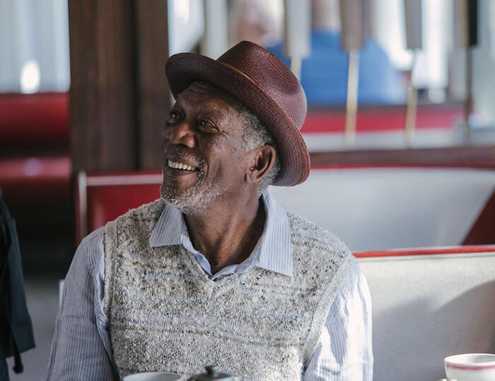 A smiling male celebrity with a fedora, white shirt, and knitted vest. Many people are disillusioned by their favorite celebrities.