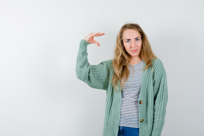 A woman with long blonde hair gestures with her hand, illustrating a common gesture associated with 'white phrases'.