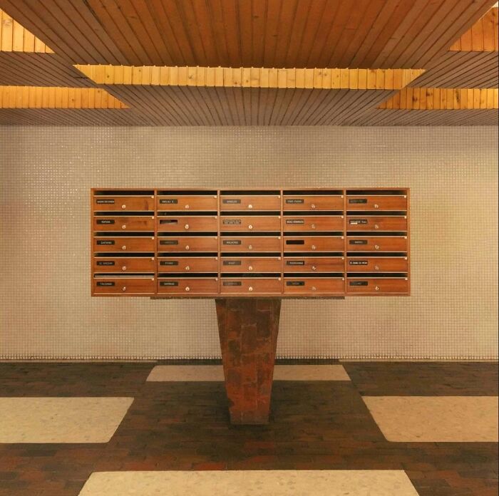 An indoor view showcasing a wall of mailboxes on a pedestal, emphasizing the unique historic interiors and their remarkable designs.