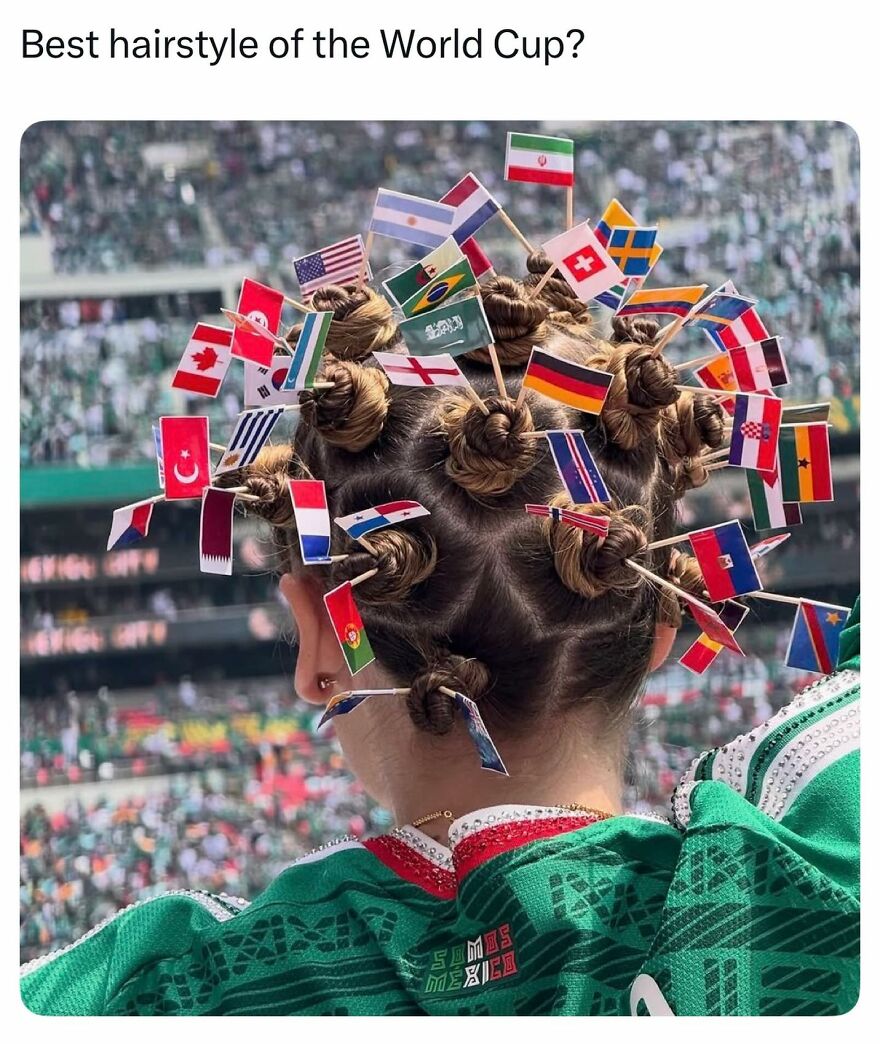 A person with an intricate hairstyle adorned with many small flags from different countries, representing World Cup chaos.