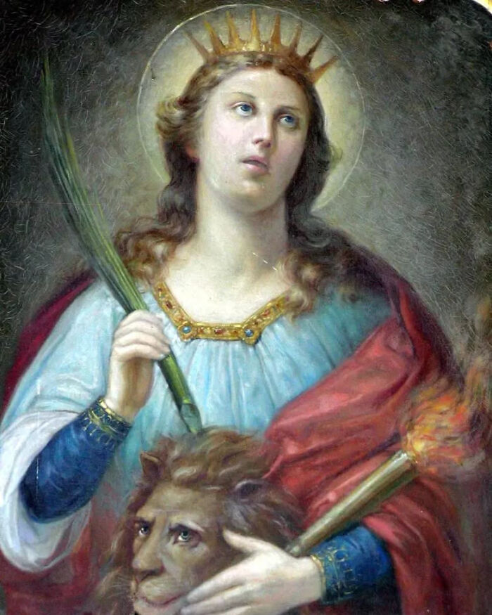 An oil painting of a crowned female saint holding a palm frond and a lions head, a powerful woman often overlooked in history.