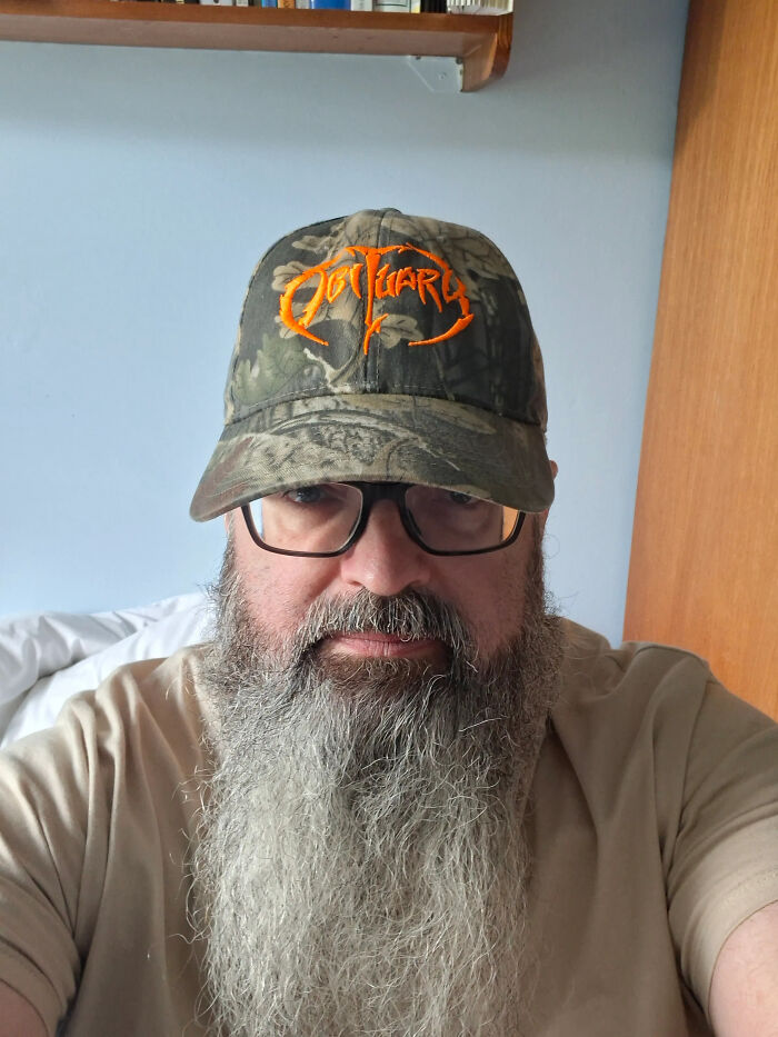A man with a long grey beard and a camouflage hat, whose looks don't match surprising facts.