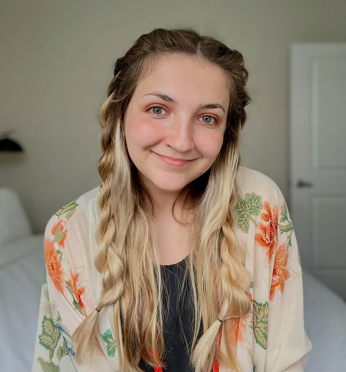 A young woman with braided hair smiling, illustrating surprising facts that don't match people's looks.