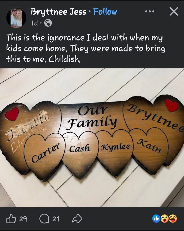 A wooden heart-shaped plaque with Our Family and the names Bryttnee, Carter, Cash, Kynlee, and Kain. An example of abominable names.