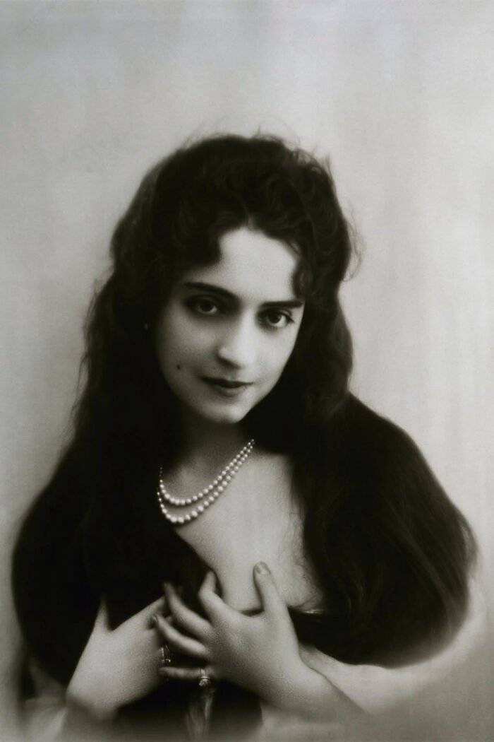 A black and white portrait of a woman with long dark hair, wearing pearls, representing overlooked women in history.