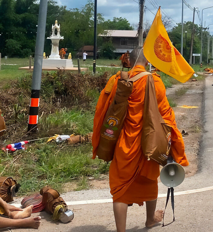 Buddhist monks walking on a road where some items are scattered, after a tragic incident involving a pickup truck. Buddhist monks walking on a road where some items are scattered, after a tragic incident involving a pickup truck.