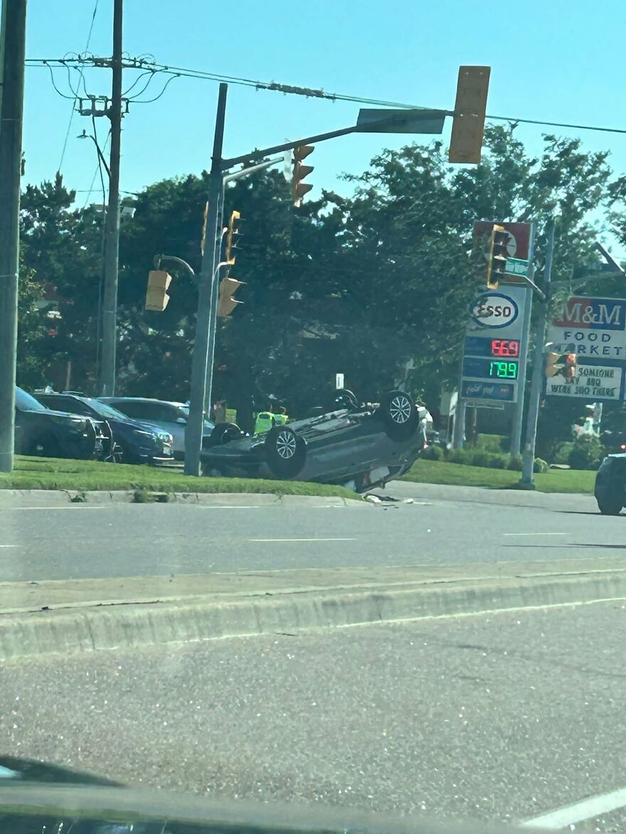 A car overturned on a busy street, a rough day behind the wheel for the driver.