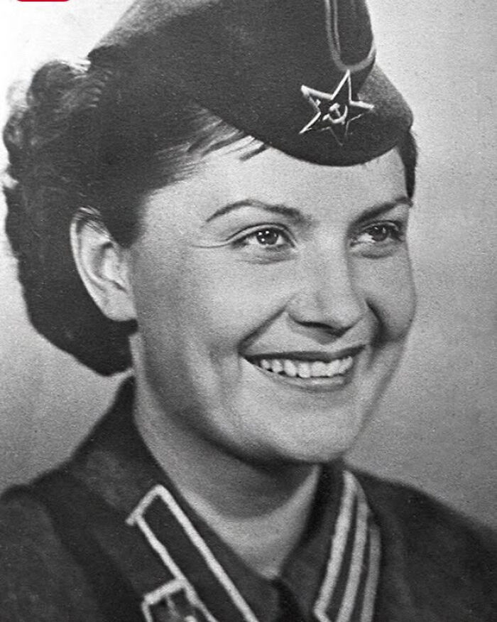 A black and white close-up of a smiling woman in a military uniform, representing overlooked women in history.