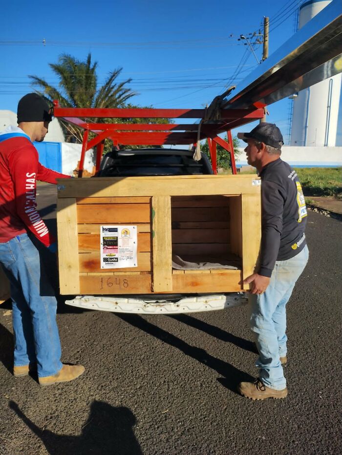Two men, including a truck driver from Brazil, load a wooden animal shelter onto a truck, for animals in need. Two men, including a truck driver from Brazil, load a wooden animal shelter onto a truck, for animals in need.