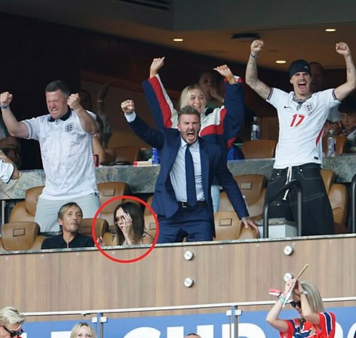 Victoria Beckham is circled in red, appearing to cover her face while David Beckham celebrates at the World Cup. Victoria Beckham is circled in red, appearing to cover her face while David Beckham celebrates at the World Cup.