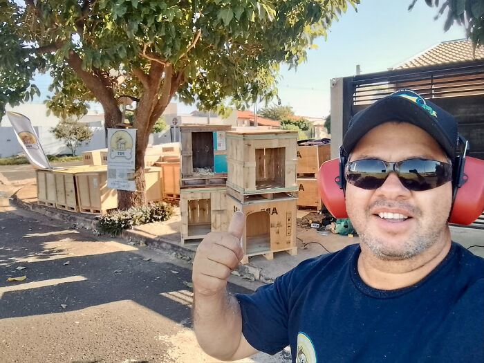 A Brazilian truck driver smiling and giving a thumbs up, with animal shelters in the background for animals in need. A Brazilian truck driver smiling and giving a thumbs up, with animal shelters in the background for animals in need.