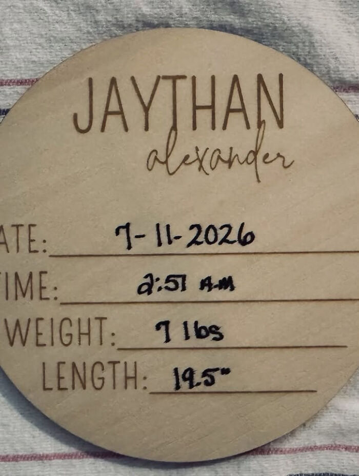 A wooden birth announcement sign for baby Jaythan Alexander, dated 7-11-2026, showcasing modern baby names.