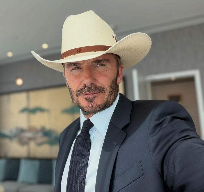 David Beckham in a cowboy hat, defending Victoria Beckham's behavior amidst public scrutiny. David Beckham in a cowboy hat, defending Victoria Beckham's behavior amidst public scrutiny.