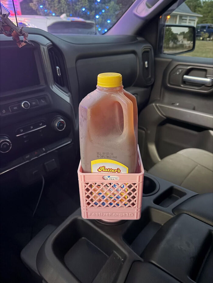 A gallon jug of iced tea in a pink miniature crate, a useful thing created with a 3D printer, in a car console.