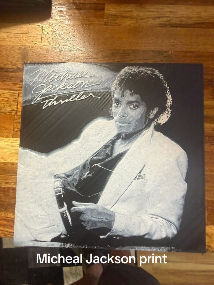 A 3D printer creation, a Michael Jackson Thriller album cover print in monochrome, lying on a wooden floor.