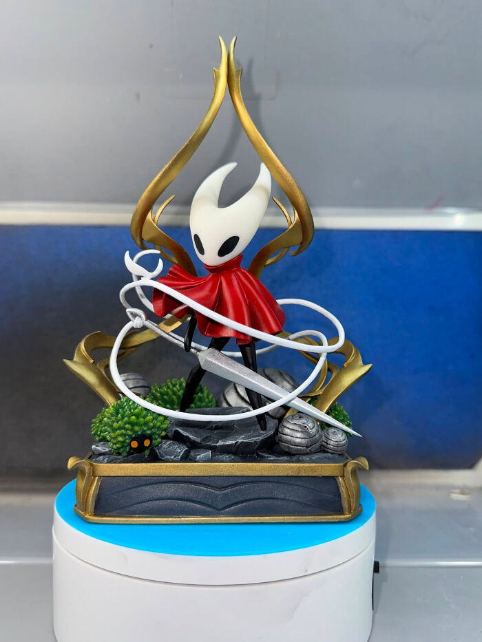 A detailed 3D printer model of the character Hornet from Hollow Knight, standing on a themed base.