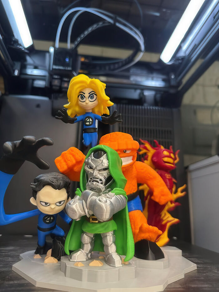 A group of 3D printed Marvel superhero figurines, including Doctor Doom, in a detailed display.
