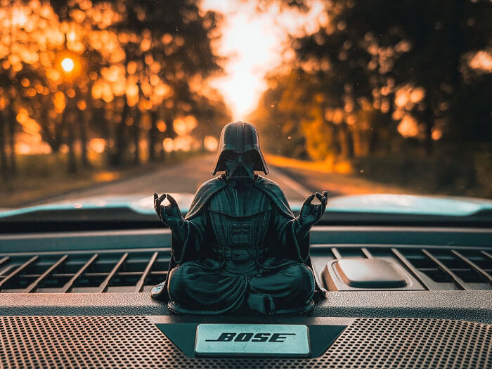 A Darth Vader figurine 3D printed in a meditative pose on a car dashboard. A cool 3D printed item.