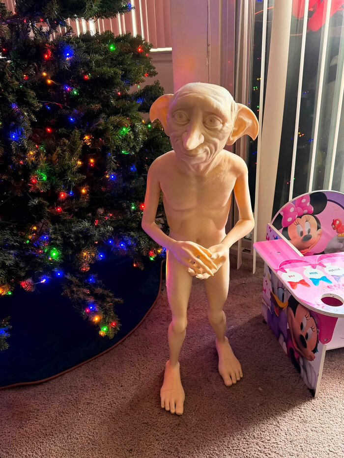 A life-sized 3D printer creation of Dobby from Harry Potter standing next to a Christmas tree.