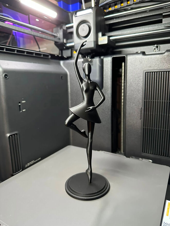 A black ballerina figurine, a cool and useful thing created with a 3D printer, standing gracefully.