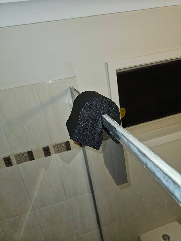 A custom black foam bumper on a metal bar, a useful thing people created with a 3D printer for protection.