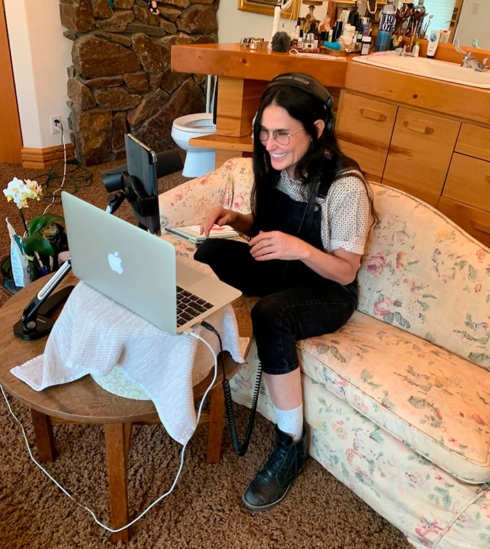 Demi Moore on a floral couch, smiling while using a laptop and headphones, showing questionable renovations in celeb homes. Demi Moore on a floral couch, smiling while using a laptop and headphones, showing questionable renovations in celeb homes.