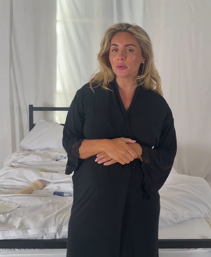 Bonnie Blue in a black robe, standing in a messy room with a baby-themed stunt, hinting at what happened.