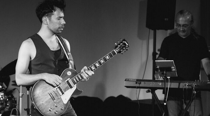 A guitarist and keyboard player performing live, showcasing different music tastes and genres.